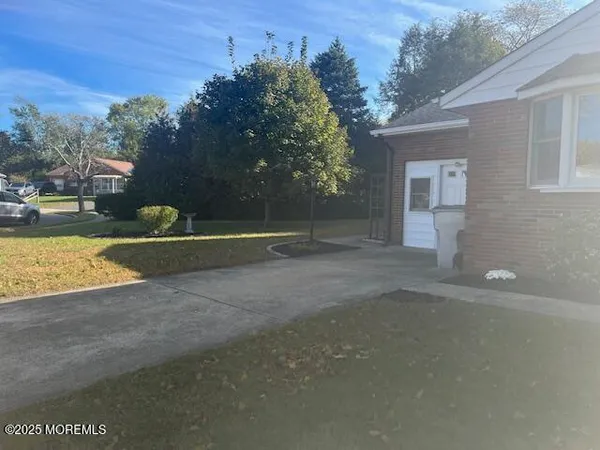 a view of a house with a yard and a large parking space