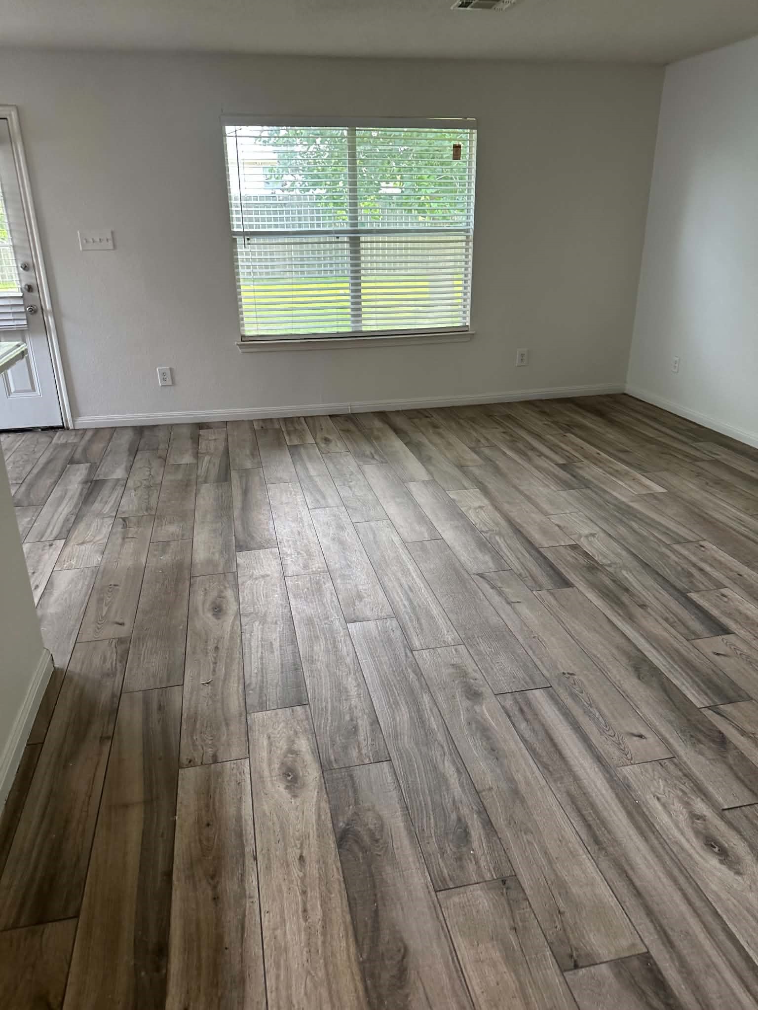 18312 Crestwind Lane Elgin, TX 78621 - Photo 12 of 15 Wood-look tile flooring flows throughout this adaptable living space, ready for your personalized touch.