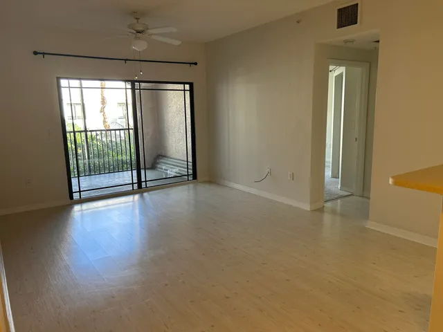 an empty room with wooden floor and sliding door