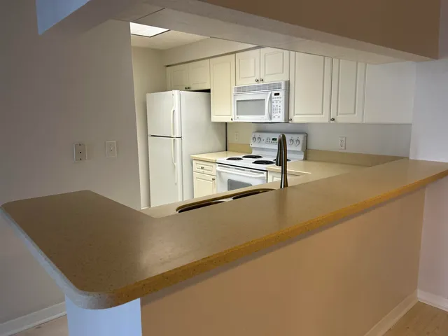a kitchen with stainless steel appliances a refrigerator sink and white cabinets