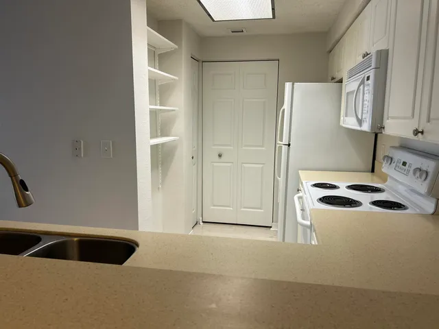 a kitchen with a refrigerator and a sink
