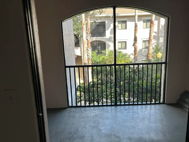 a view of a glass door with a balcony from a window