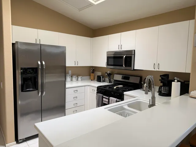 a kitchen with a refrigerator and a stove top oven