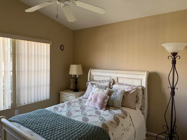a bed sitting in a bedroom next to a window and a chandelier