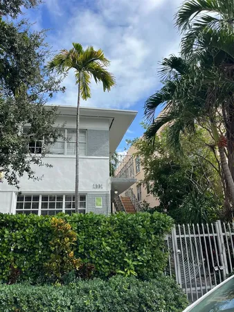 a view of a house with a yard and potted plants