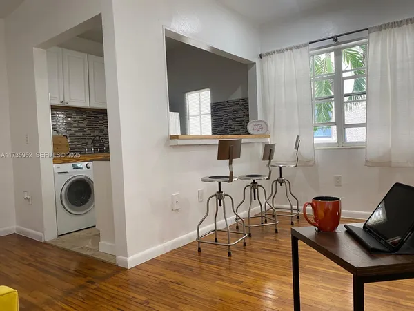 a view of a workspace with wooden floor and a window