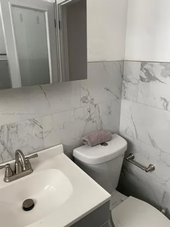 a white toilet sitting next to a bathroom sink