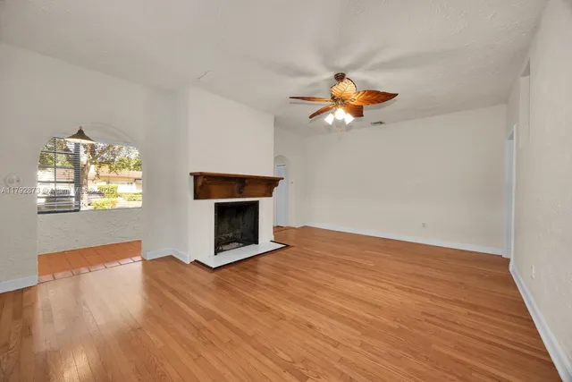 a living room with wooden floor and a fireplace