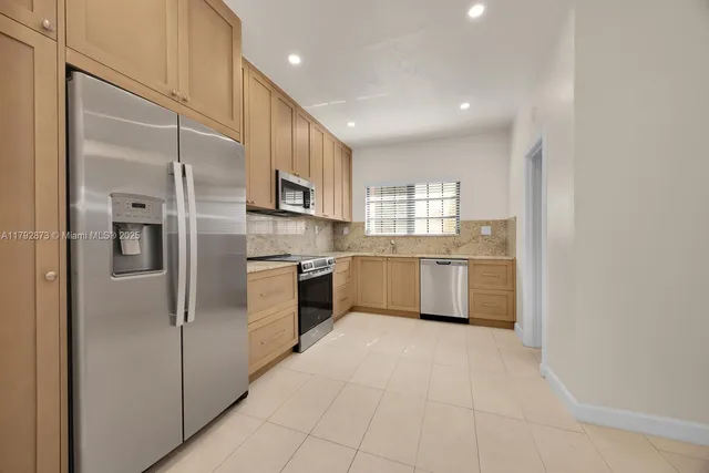 a kitchen with stainless steel appliances a refrigerator sink and cabinets