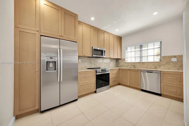 a kitchen with a refrigerator sink and cabinets