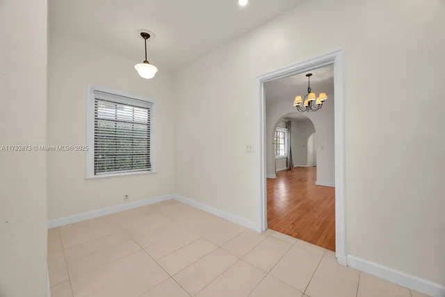 an empty room that has a window and wooden floor