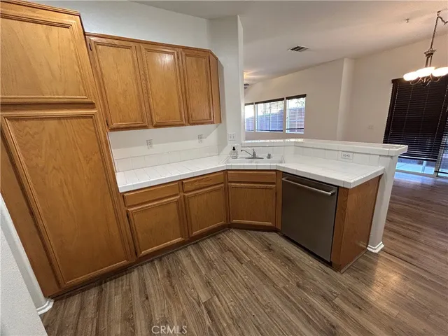 a kitchen with a sink a refrigerator and wooden floor