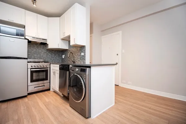 a utility room with wooden floor washer and dryer