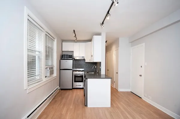 a kitchen with stainless steel appliances a refrigerator sink and cabinets