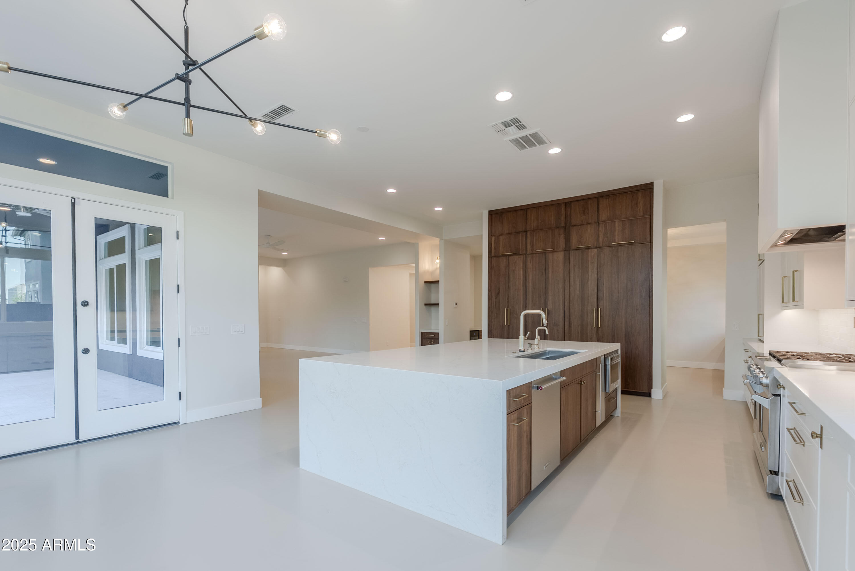 3145 East Boot Track Trail Gilbert, AZ 85296 - Photo 13 of 17 a large kitchen with a large counter top a stove a sink and a refrigerator