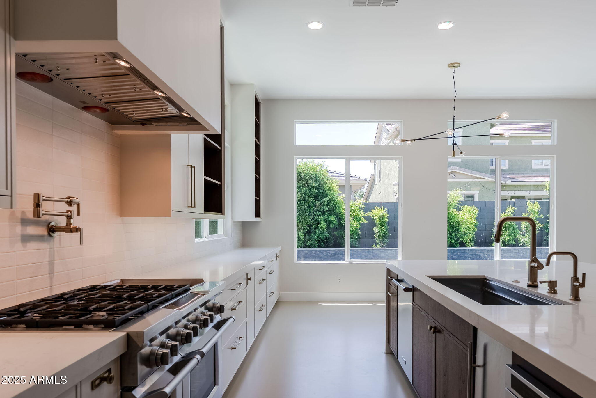 3145 East Boot Track Trail Gilbert, AZ 85296 - Photo 2 of 17 a kitchen with stainless steel appliances granite countertop a sink stove and cabinets