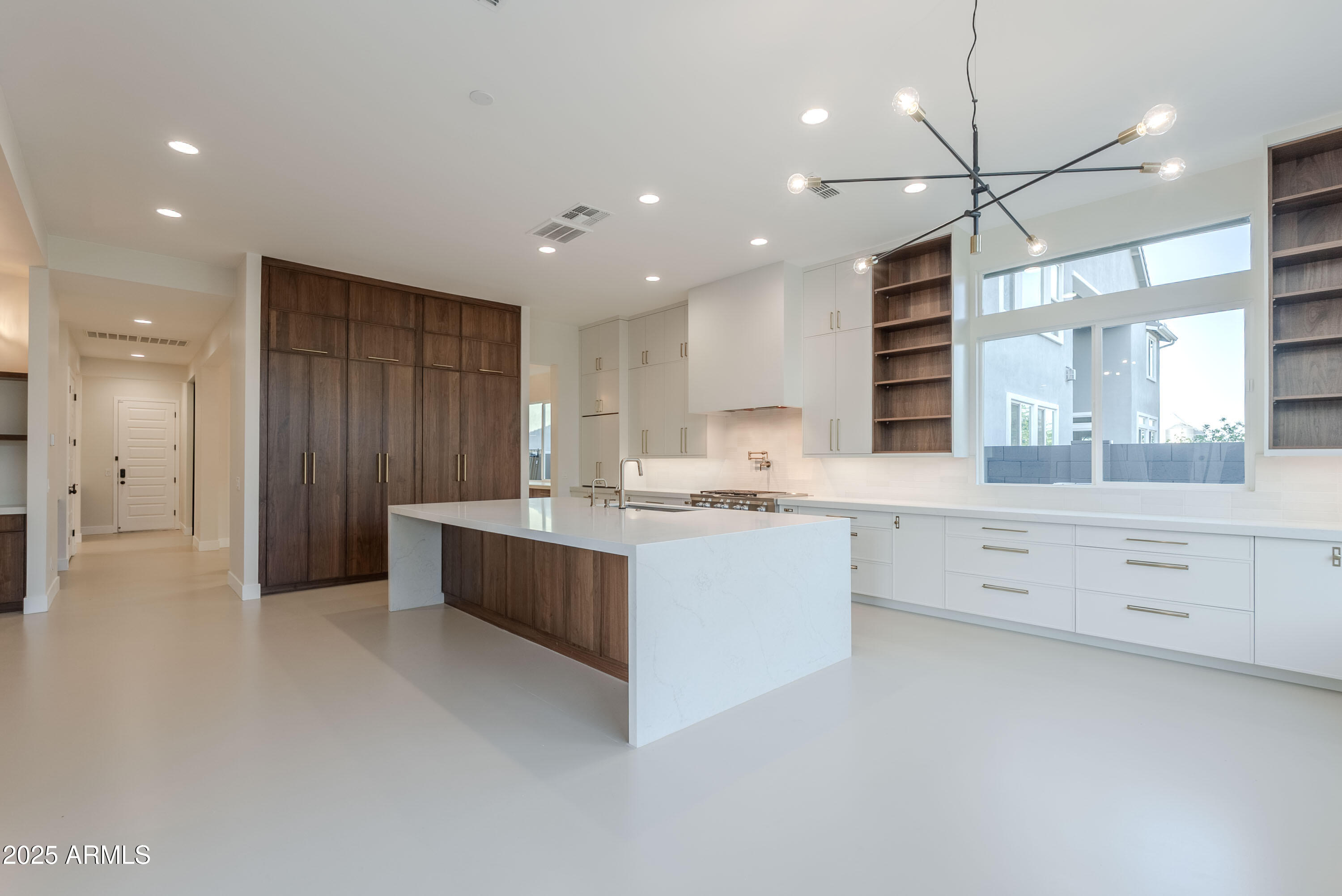 3145 East Boot Track Trail Gilbert, AZ 85296 - Photo 8 of 17 a large white kitchen with a large window a sink and stainless steel appliances