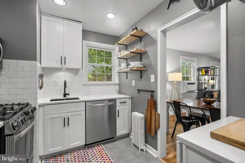 a kitchen with stainless steel appliances a sink stove and cabinets