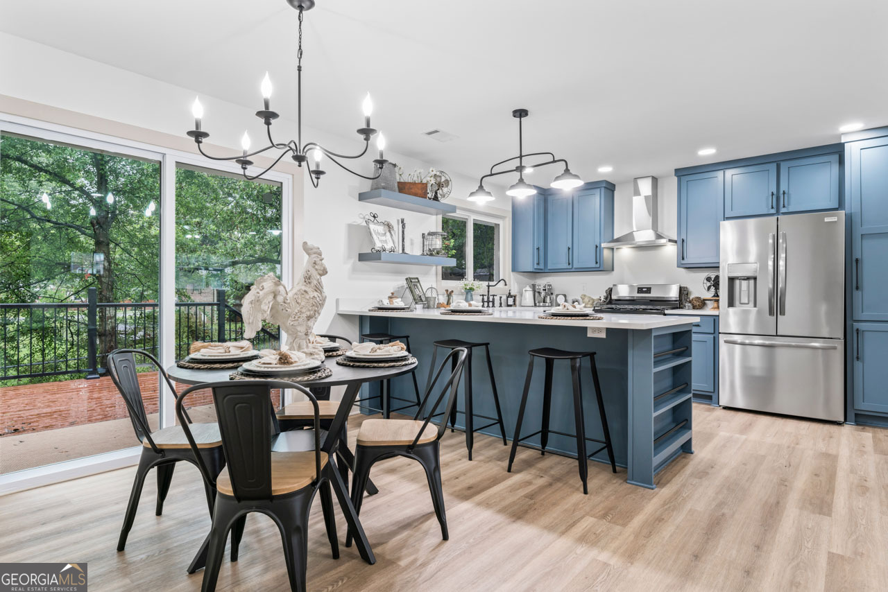 9 Lemon Street McDonough, GA 30253 - Photo 25 of 42 a kitchen with stainless steel appliances granite countertop a stove a refrigerator a oven a sink with a dining table and chairs