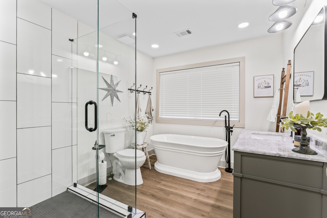 9 Lemon Street McDonough, GA 30253 - Photo 32 of 42 a bathroom with a granite countertop sink a toilet a mirror and shower