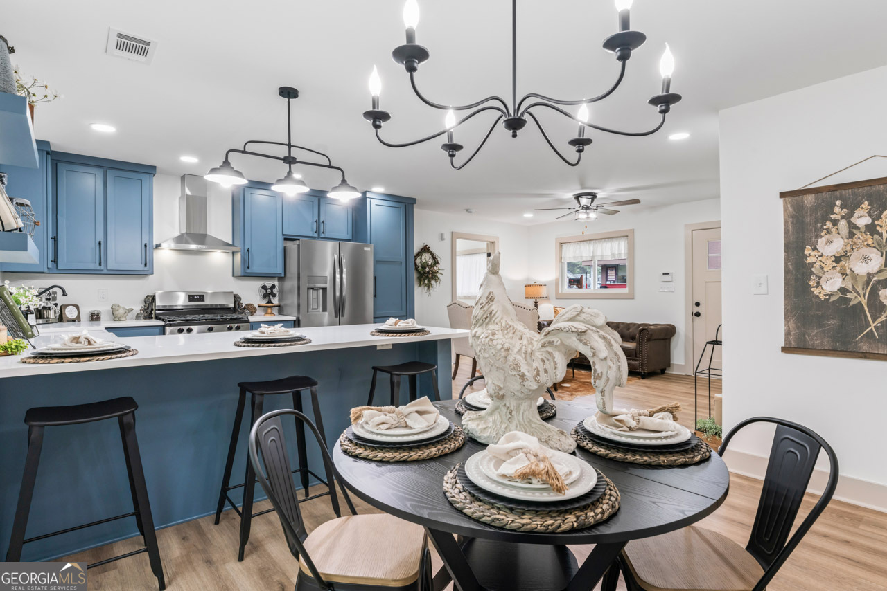 9 Lemon Street McDonough, GA 30253 - Photo 35 of 42 a kitchen with stainless steel appliances granite countertop a dining table and chairs with wooden floor