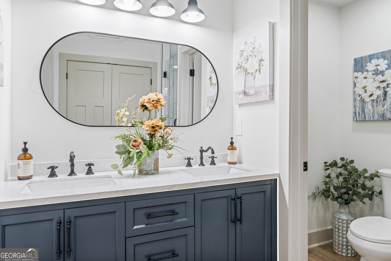 9 Lemon Street McDonough, GA 30253 - Photo 39 of 42 a bathroom with a toilet a sink and a mirror