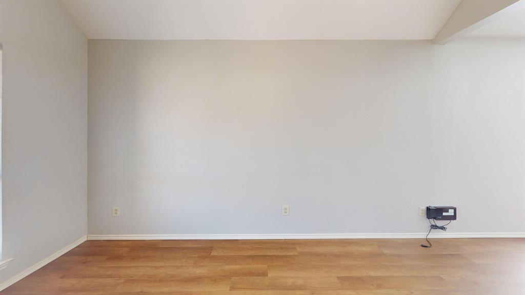 7913 Rice Drive Rowlett, TX 75088 - Photo 8 of 25 Spacious room featuring light-toned walls, wood-finish flooring, and crisp white baseboards