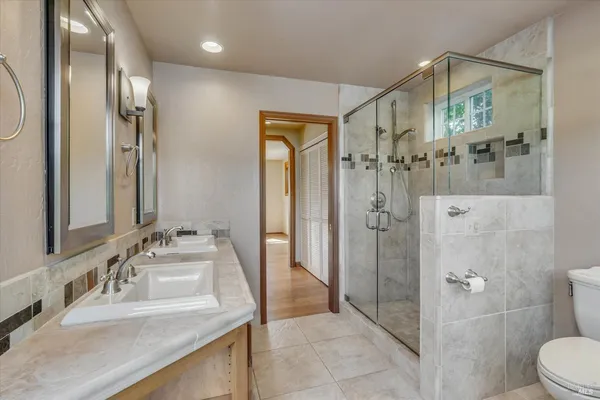 a bathroom with a granite countertop sink mirror and shower
