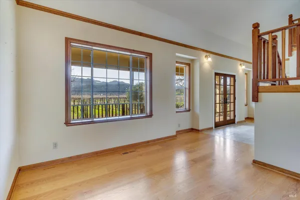 a view of an empty room with window and wooden floor