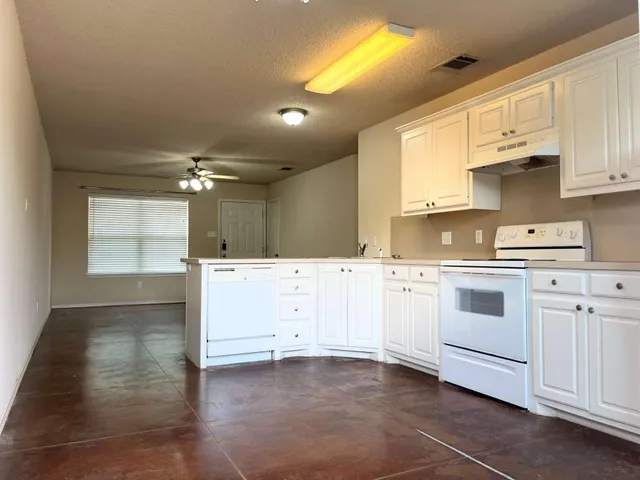 a kitchen with white cabinets and white appliances