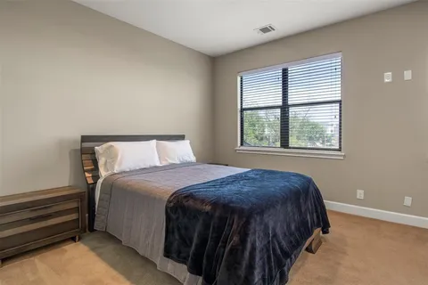 a bed sitting in a bedroom next to a window