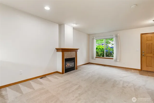 a view of an empty room with a fireplace and a window