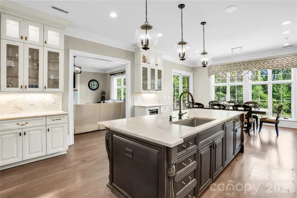 a large kitchen with kitchen island a stove a sink a dining table and chairs
