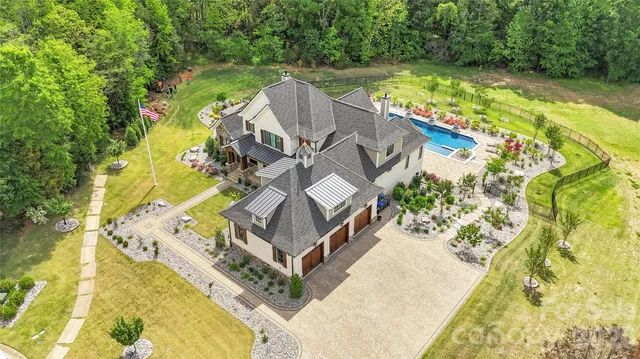 an aerial view of a residential houses with yard and swimming pool