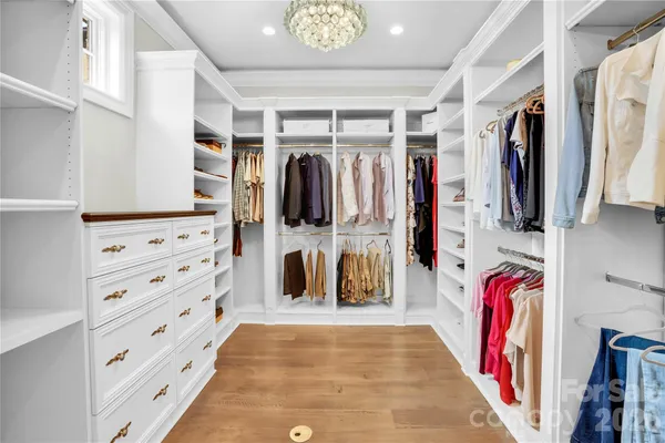 a view of walk in closet with clothes