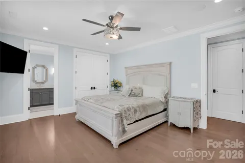 a spacious bedroom with a bed and a flat screen tv
