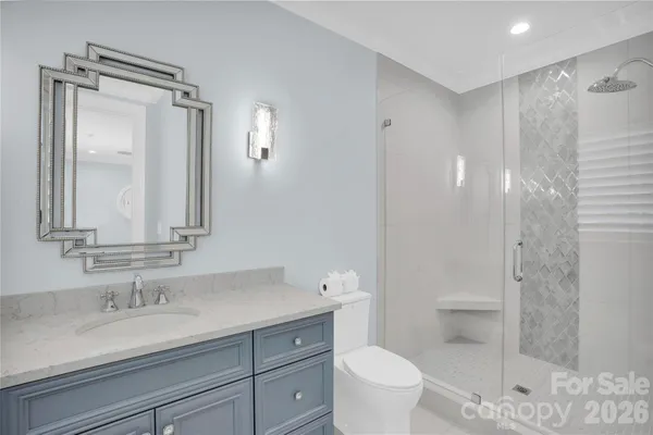 a bathroom with a granite countertop sink a toilet and a mirror