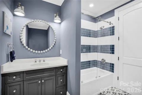 a bathroom with a tub sink and mirror
