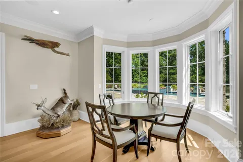 a living room with stainless steel appliances furniture a rug and a kitchen view