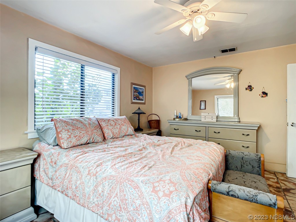 208 Crawford Road New Smyrna Beach, FL 32169 - Photo 11 of 26 a bedroom with a large bed and a chandelier
