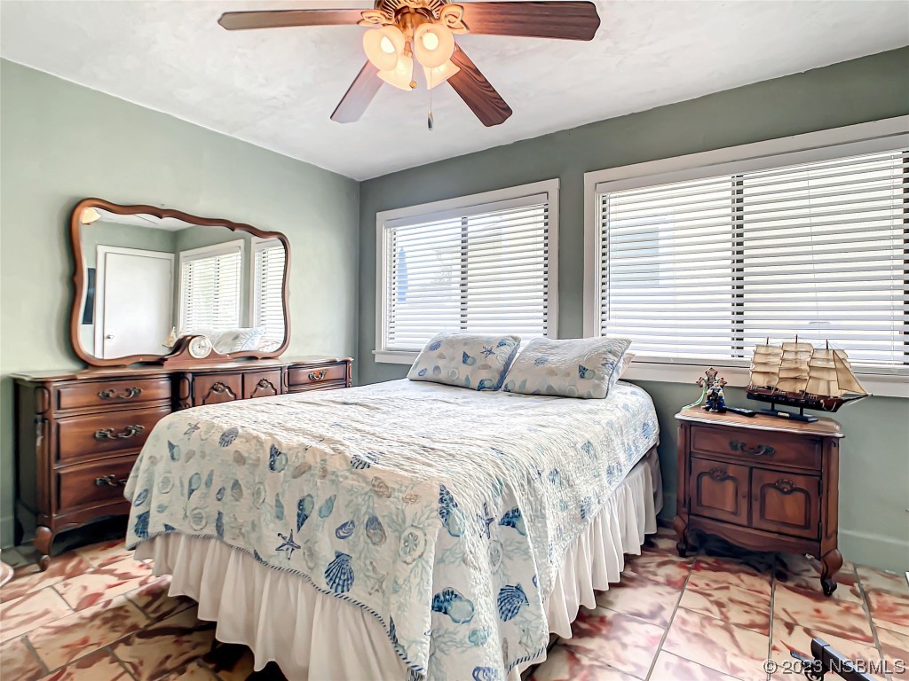 208 Crawford Road New Smyrna Beach, FL 32169 - Photo 12 of 26 a bedroom with a bed and a chandelier