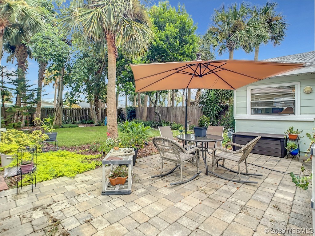 208 Crawford Road New Smyrna Beach, FL 32169 - Photo 7 of 26 a view of a patio with a table and chairs under an umbrella