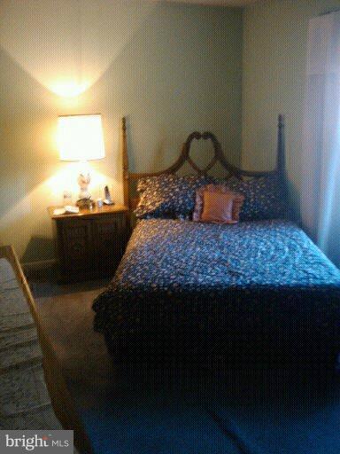 6473 Rockshire Court Alexandria, VA 22315 - Photo 7 of 12 a bed sitting in a bedroom next to a lamp