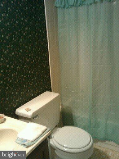 6473 Rockshire Court Alexandria, VA 22315 - Photo 9 of 12 a bathroom with a toilet and a shower curtain