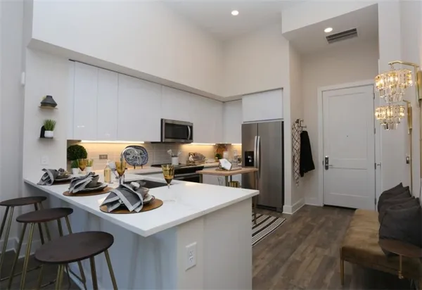 a living room with furniture a chandelier and a dining table