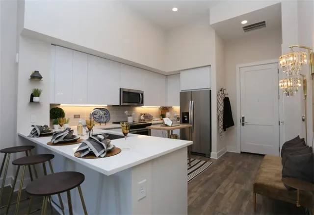a living room with furniture a chandelier and a dining table