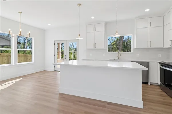 a kitchen with kitchen island a counter top a stove and a wooden floors