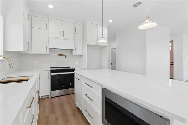 a kitchen with white cabinets and white appliances