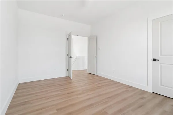 a view of an empty room with wooden floor