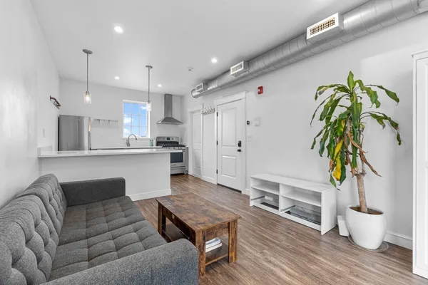 a living room with furniture and wooden floor
